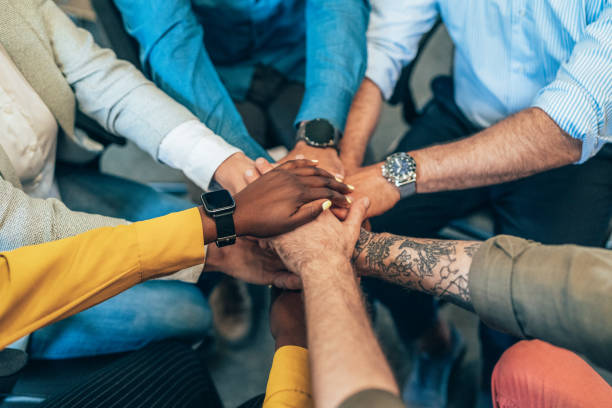 Unrecognizable multi ethnic business team holding their hands together. Modern business team holding hands like successful team.